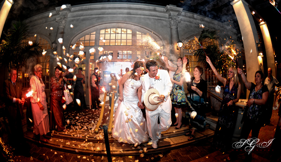 wedding-Galvez-hotel-sendoff Newlywed couple leaving their reception with guests holding sparklers.